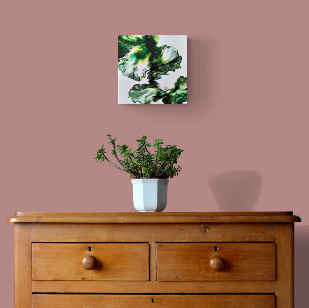Tableau posé sur un mur aux côtés d'une plante verte